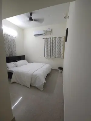 a bedroom with two beds and a ceiling fan at Happy Home in Coimbatore