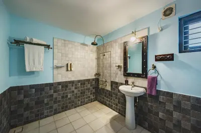 a bathroom with a sink and a mirror at SaffronStays Calamondinn Bungalow - 5BR Colonial Heritage Home within Coffee Plantation in Coorg in Gonikoppal