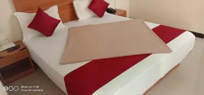 a bed with red and white sheets and red pillows at Red Star Holidays in Munnar