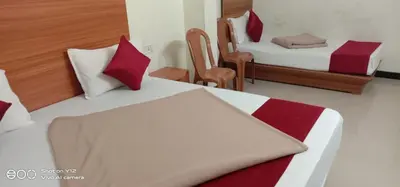 a bedroom with two beds with red and white pillows at Red Star Holidays in Munnar