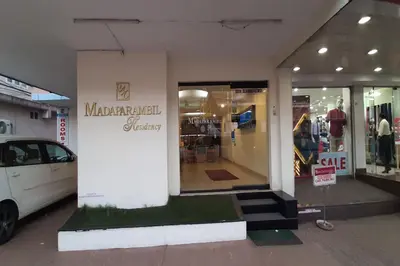 a store front with a car parked in front of it at MADAPARAMBIL RESIDENCY in Alwaye