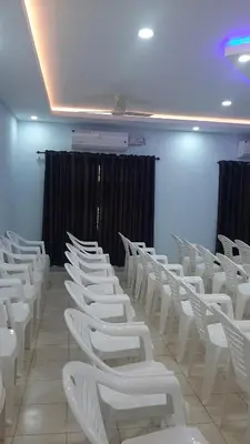 a row of white chairs in a room at MADAPARAMBIL RESIDENCY in Alwaye
