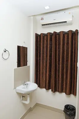 a bathroom with a sink and a shower curtain at GREEN LINE RESIDENCY in Nedumbassery