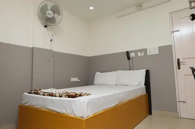 a small bedroom with a bed with a fan at GREEN LINE RESIDENCY in Nedumbassery