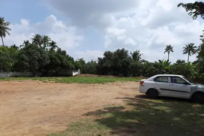 a white car parked on a dirt road at GREEN LINE RESIDENCY in Nedumbassery
