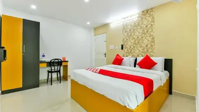 a bedroom with a large bed with red pillows at GREEN LINE RESIDENCY in Nedumbassery
