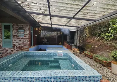 a swimming pool with blue tiles on a house at Wild root stay- Orchid Chalet in Vythiri