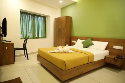 a bedroom with a bed with two stuffed animals on it at Hillfort Inn in Sultan Bathery