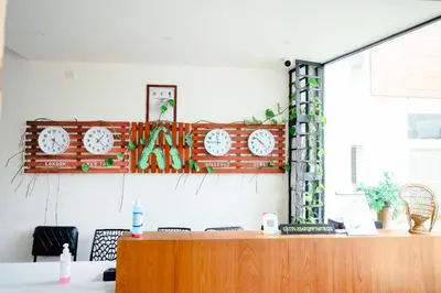a wall with clocks on the wall in an office at Hillfort Inn in Sultan Bathery