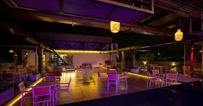 a room with purple chairs and tables and lights at Hotel M Pro Palace Mysore - 12 Minutes to Mysore Palace in Mysore