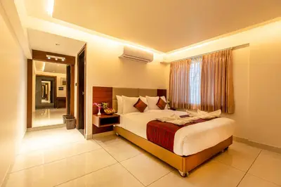 a bedroom with a large bed and a window at Hotel M Pro Palace Mysore - 12 Minutes to Mysore Palace in Mysore