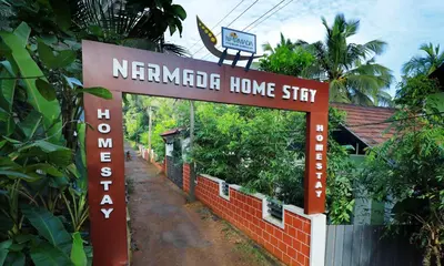 a sign for the entrance to a neyerndra home stay at NARMADA HOMESTAY Ganga in Perintalmanna