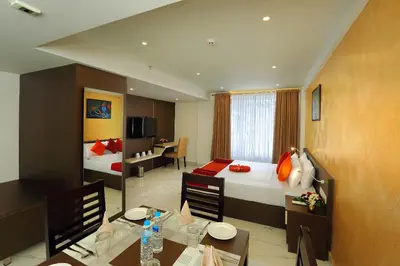 a hotel room with two beds and a dining room at Renai Sreekrishna in Guruvāyūr
