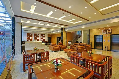 a hotel room with tables and chairs and a lobby at Renai Sreekrishna in Guruvāyūr