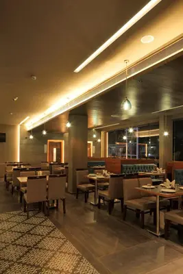 a dining room with tables and chairs in a restaurant at GRANDE IRIS in Sultan Bathery