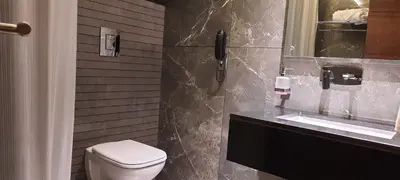 a bathroom with a toilet and a sink at GRANDE IRIS in Sultan Bathery