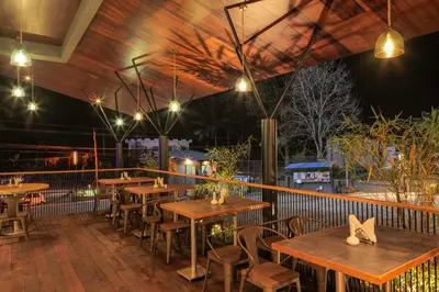 a restaurant with wooden tables and chairs and lights at GRANDE IRIS in Sultan Bathery