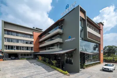 an office building with a car parked in front of it at GRANDE IRIS in Sultan Bathery