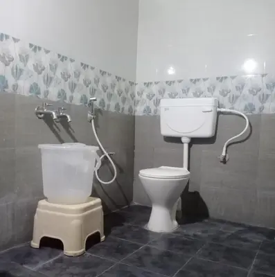 a bathroom with a toilet and a sink in it at KABINI FARM STAY in Antarasante