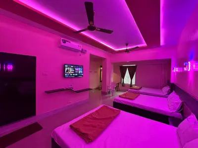 a pink room with two beds and a tv at Sivamurugan residency in Bhavāni