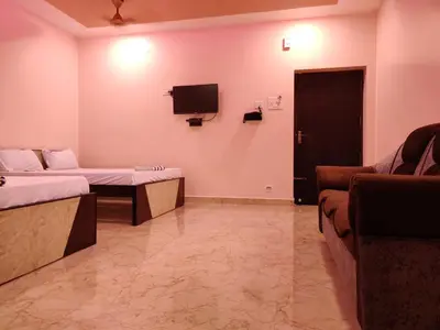 a room with two beds and a tv and a couch at Sivamurugan residency in Bhavāni