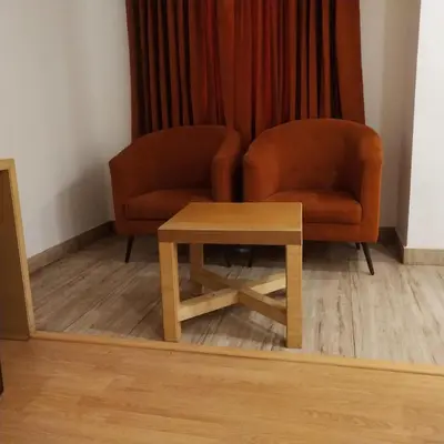 a living room with a chair and a table at PPH Living Railotel Coimbatore in Coimbatore