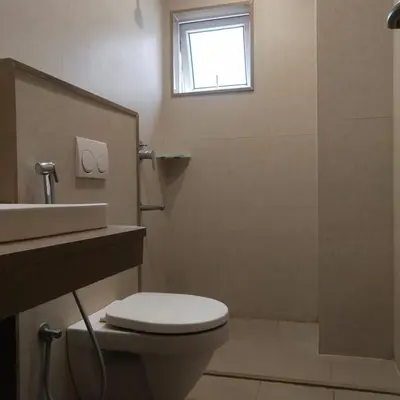 a bathroom with a toilet and a sink and a window at PPH Living Railotel Coimbatore in Coimbatore