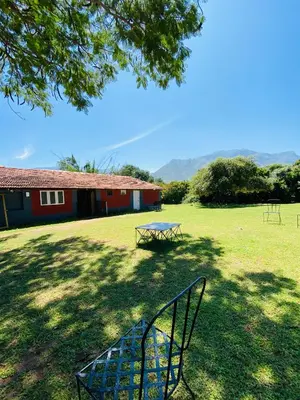 a picnic table in a field next to a building at Runnel View in Masinagudi