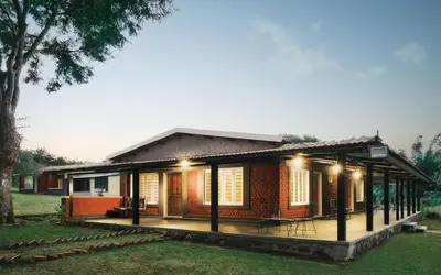a small house with lights on in a yard at Runnel View in Masinagudi