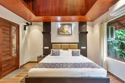 a bedroom with a large bed with a wooden ceiling at Serene Valley Resort Wayanad in Mananthavady
