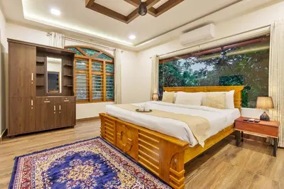 a bedroom with a large bed and a large window at Serene Valley Resort Wayanad in Mananthavady