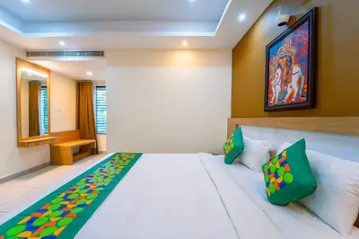 a bedroom with a large white bed with green pillows at Treebo Sree Varshavilas Regency, 500 Mtrs From Guruvayoor Temple in Guruvāyūr
