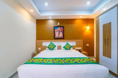 a bedroom with a large white bed with colorful pillows at Treebo Sree Varshavilas Regency, 500 Mtrs From Guruvayoor Temple in Guruvāyūr