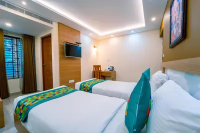 a hotel room with two beds and a flat screen tv at Treebo Sree Varshavilas Regency, 500 Mtrs From Guruvayoor Temple in Guruvāyūr
