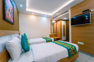 a bedroom with a bed and a tv on the wall at Treebo Sree Varshavilas Regency, 500 Mtrs From Guruvayoor Temple in Guruvāyūr