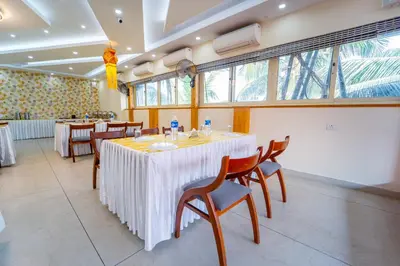 a dining room with a table and chairs at Treebo Sree Varshavilas Regency, 500 Mtrs From Guruvayoor Temple in Guruvāyūr