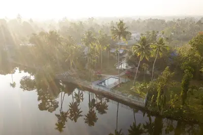 an aerial view of a river with palm trees at Lhasa Ayurveda and Wellness Resort - A BluSalzz Collection, Kochi, Kerala in Cochin
