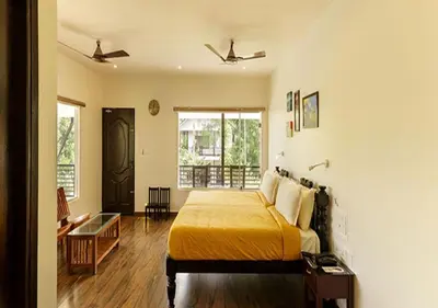 a bedroom with a bed with a yellow blanket at Lhasa Ayurveda and Wellness Resort - A BluSalzz Collection, Kochi, Kerala in Cochin