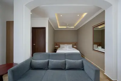 a bedroom with a bed and a blue couch at Tea Garden Riverside in Munnar