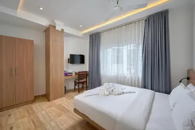 a bedroom with a white bed and a desk at Tea Garden Riverside in Munnar