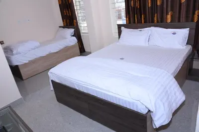 a bedroom with two twin beds with white sheets at Yashas Paradise in Nanjangūd