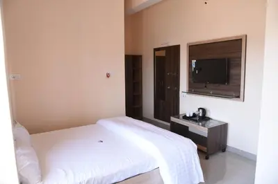 a bedroom with a bed and a tv on the wall at Yashas Paradise in Nanjangūd