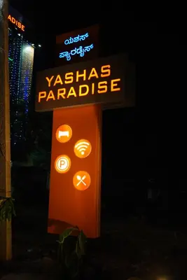 a sign that says vashiasparade with a neon sign at Yashas Paradise in Nanjangūd