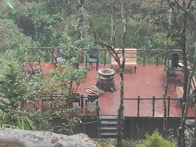 a patio with chairs and a fountain in a garden at The Wild Trails Clarks Exotica , Munnar in Munnar