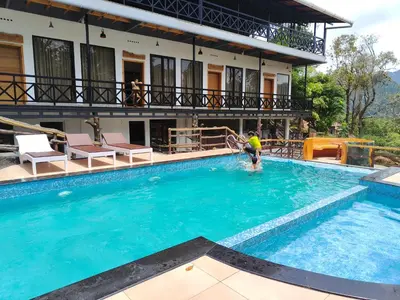 a person playing in the water in a swimming pool at The Wild Trails Clarks Exotica , Munnar in Munnar
