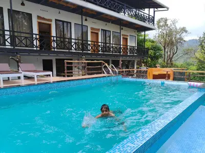 a person swimming in a swimming pool at The Wild Trails Clarks Exotica , Munnar in Munnar