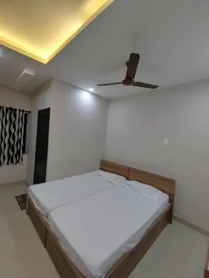 a bedroom with a bed with a ceiling fan at The Grand Inn in Kanjikode