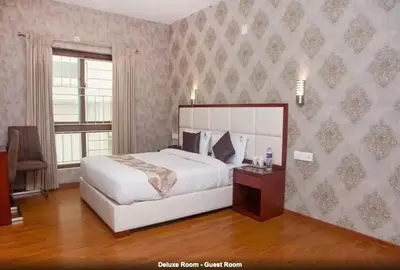 a bedroom with a large white bed and a window at Hillcrest Metro in Ooty