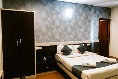 a bedroom with two beds and a wall at Hillcrest Metro in Ooty