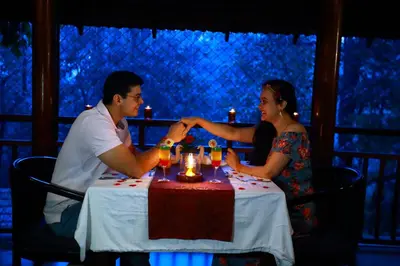 a man and a woman sitting at a table with drinks at Vythiri Resort in Vythiri